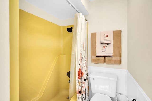 bathroom with shower / bath combination with curtain and toilet