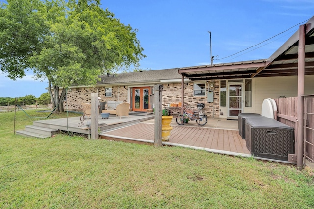 back of property featuring french doors, a yard, and a deck