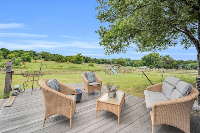 wooden deck with a rural view, an outdoor living space, a yard, and a playground