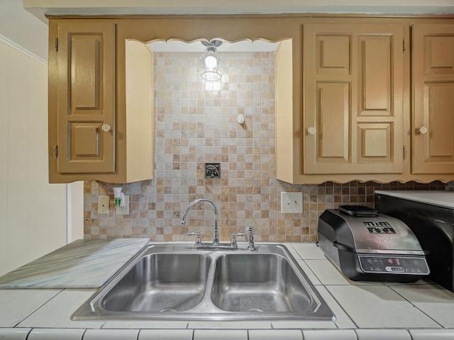 kitchen featuring sink, tile countertops, and crown molding