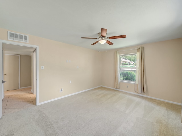 spare room featuring ceiling fan and light colored carpet