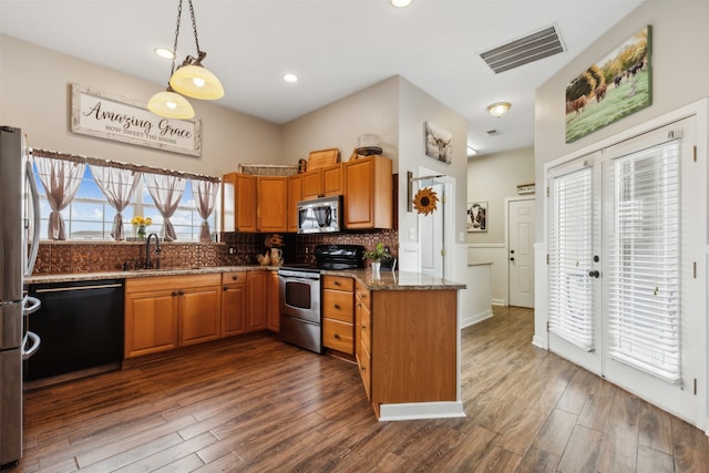 kitchen with stainless steel appliances, decorative light fixtures, plenty of natural light, and dark hardwood / wood-style flooring