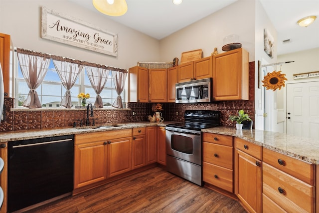 kitchen featuring dark wood-type flooring, sink, appliances with stainless steel finishes, light stone counters, and tasteful backsplash