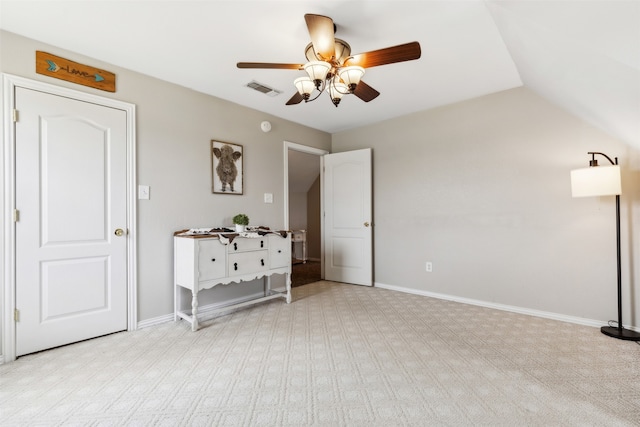 unfurnished bedroom featuring lofted ceiling, light carpet, and ceiling fan