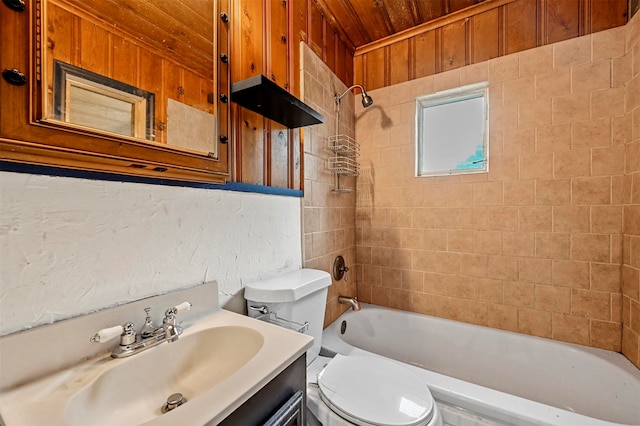 full bathroom with tiled shower / bath, vanity, wood ceiling, wooden walls, and toilet