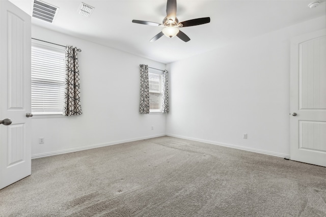 carpeted spare room with ceiling fan and a wealth of natural light