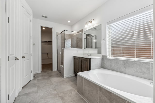 bathroom featuring a wealth of natural light, separate shower and tub, vanity, and tile patterned floors