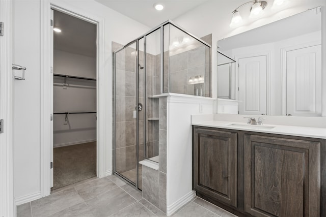 bathroom with an enclosed shower, tile patterned flooring, and vanity