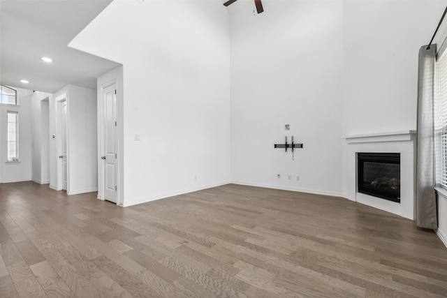 unfurnished living room featuring ceiling fan and hardwood / wood-style floors