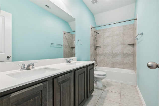 full bathroom with tile patterned flooring, toilet, tiled shower / bath, and dual bowl vanity