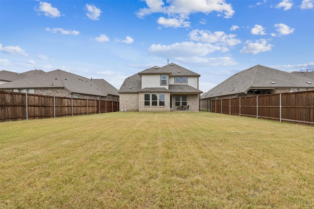 rear view of house featuring a yard