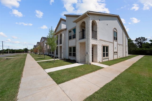 view of home's exterior with a lawn and a balcony