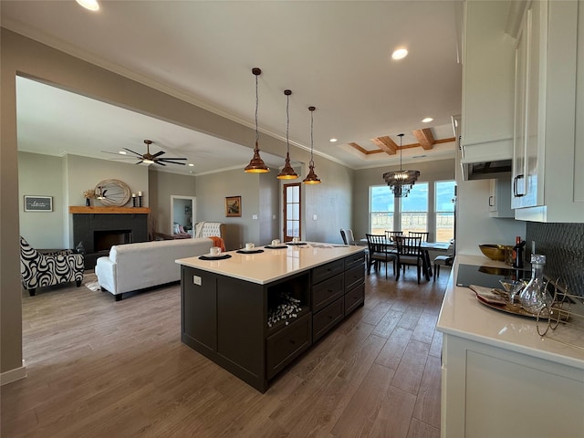 kitchen with white cabinetry, ornamental molding, a center island, and pendant lighting