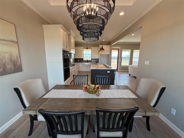 dining room with an inviting chandelier, hardwood / wood-style flooring, and ornamental molding