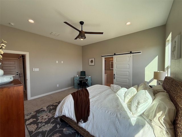 carpeted bedroom with a barn door and ceiling fan