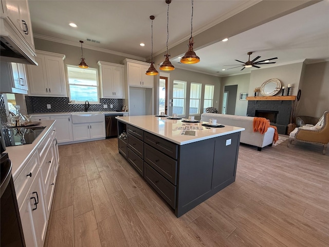 kitchen featuring white cabinetry, hanging light fixtures, a center island, black appliances, and decorative backsplash