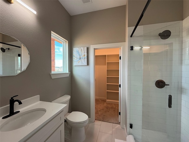 bathroom featuring walk in shower, tile patterned floors, toilet, and vanity