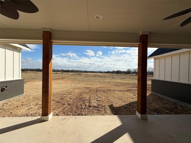 view of yard with a patio, a rural view, and ceiling fan