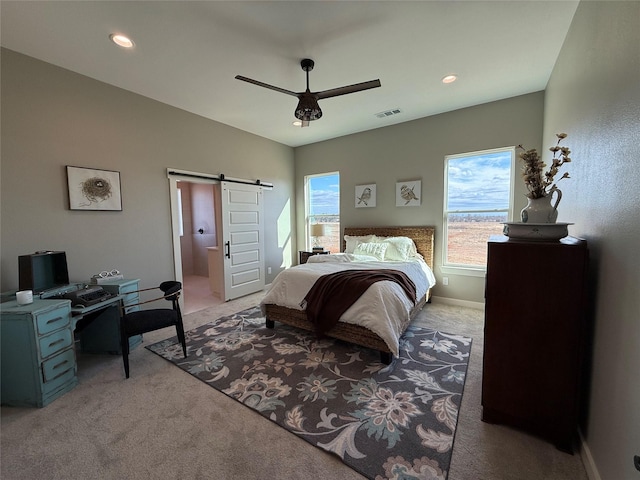 carpeted bedroom featuring a barn door and ceiling fan