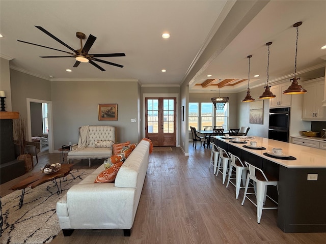 living room with crown molding, ceiling fan, and hardwood / wood-style floors