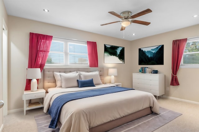 carpeted bedroom with multiple windows and ceiling fan