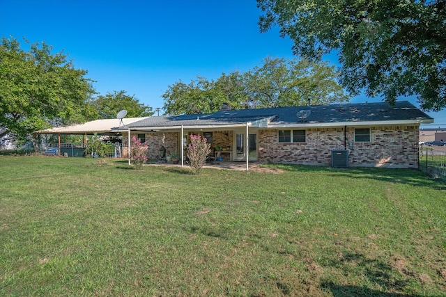 rear view of property featuring cooling unit, a lawn, and a patio area