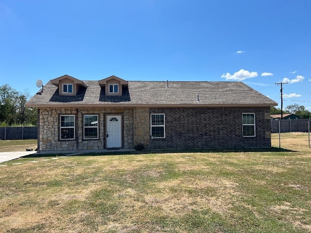 view of front of house featuring a front lawn, roof with shingles, and fence