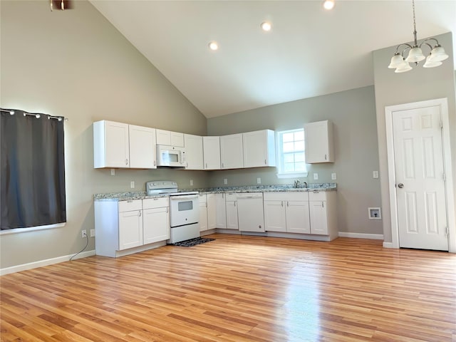 kitchen with white appliances, white cabinets, a sink, and light wood finished floors