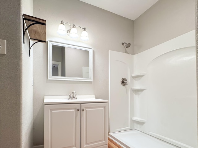 full bathroom featuring a shower and vanity