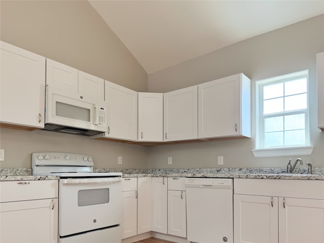 kitchen with white cabinets, vaulted ceiling, light stone countertops, and white appliances