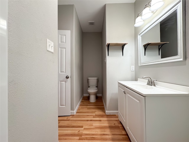 bathroom with hardwood / wood-style floors, toilet, and vanity