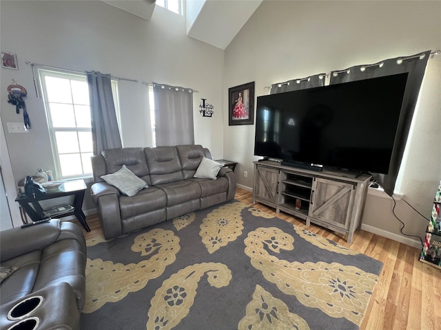 living room featuring light wood-type flooring and high vaulted ceiling