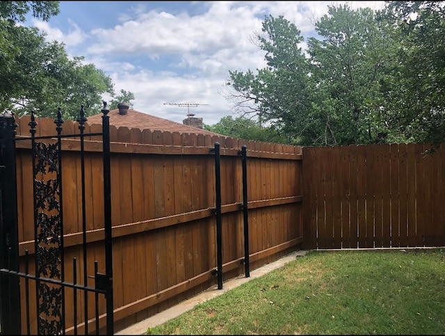 view of gate with a lawn