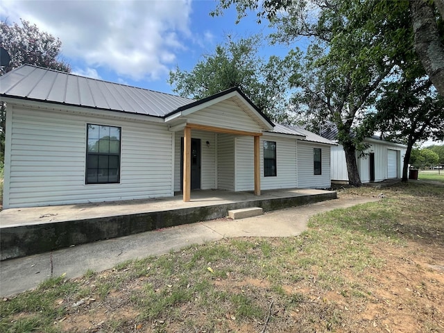 single story home with a porch, a garage, and a front lawn