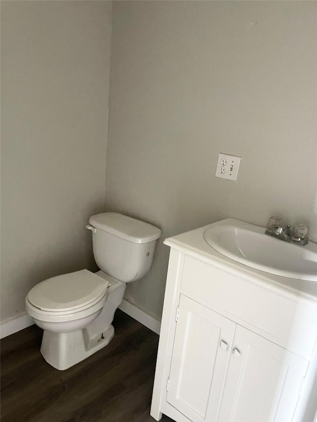 bathroom with hardwood / wood-style flooring, vanity, and toilet