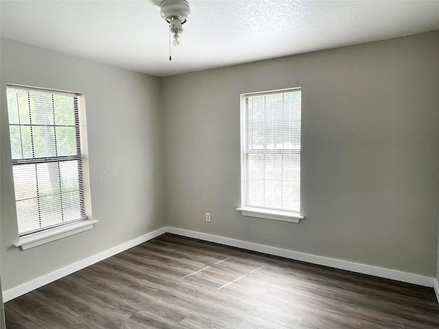 empty room with hardwood / wood-style flooring and a healthy amount of sunlight