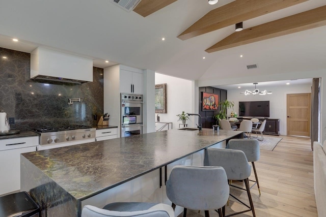 kitchen featuring tasteful backsplash, a spacious island, beamed ceiling, and white cabinets