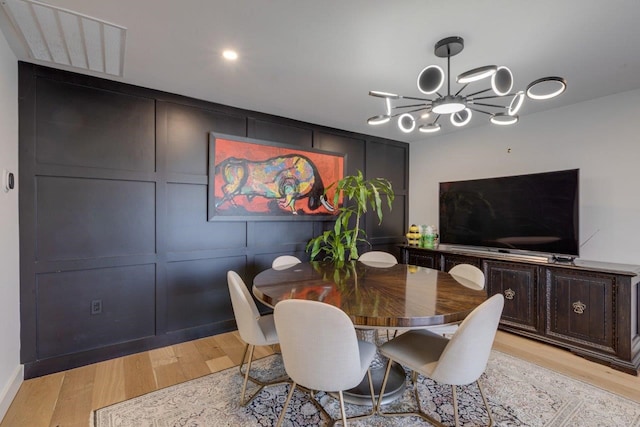 dining area featuring light hardwood / wood-style flooring and a chandelier