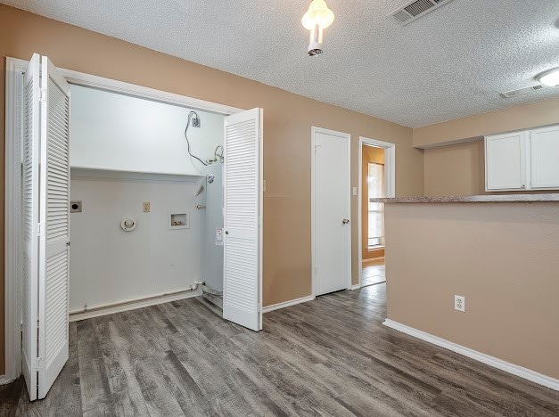 washroom featuring hookup for an electric dryer, a textured ceiling, washer hookup, and hardwood / wood-style floors