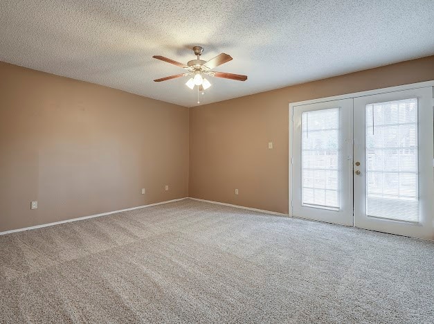 unfurnished room featuring carpet flooring, a textured ceiling, french doors, and ceiling fan