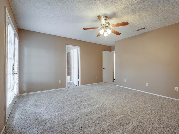 empty room with carpet flooring, a textured ceiling, and ceiling fan