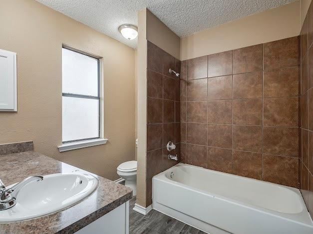 full bathroom with plenty of natural light, vanity, toilet, and hardwood / wood-style floors