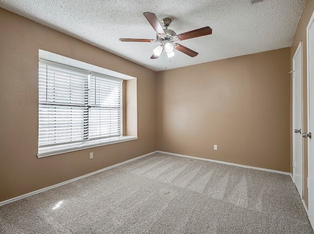 carpeted empty room featuring a textured ceiling and ceiling fan