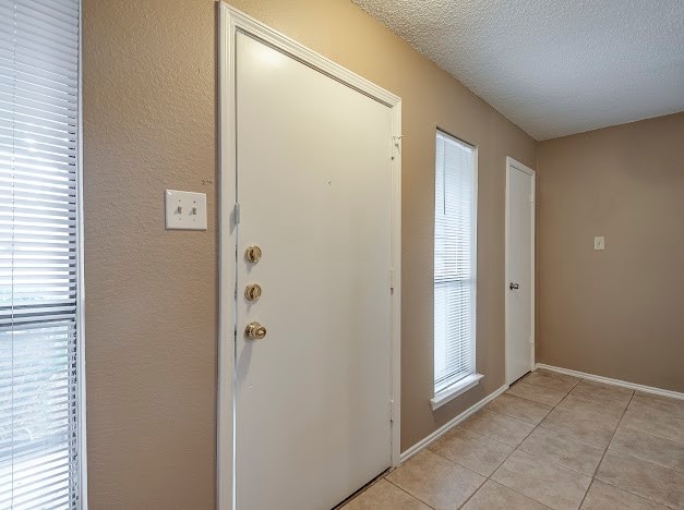 tiled foyer entrance with a textured ceiling