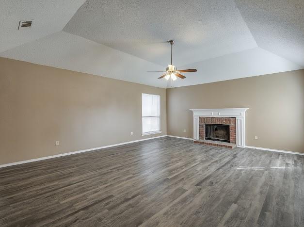 unfurnished living room with a textured ceiling, a fireplace, and hardwood / wood-style floors