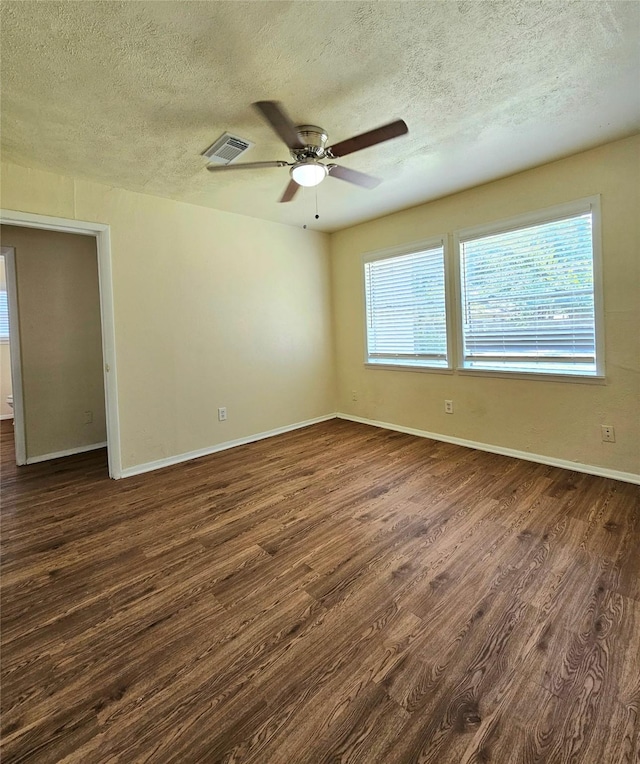 empty room featuring dark hardwood / wood-style floors, a textured ceiling, and ceiling fan