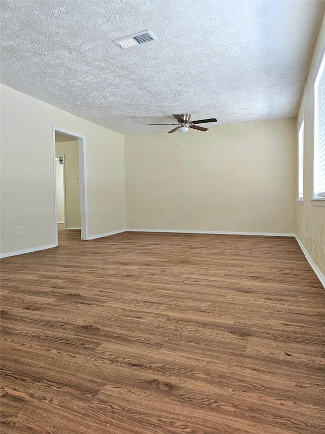 unfurnished room featuring dark hardwood / wood-style floors and a textured ceiling