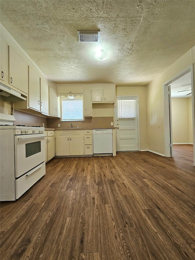 kitchen featuring dark hardwood / wood-style floors, sink, a textured ceiling, and white appliances