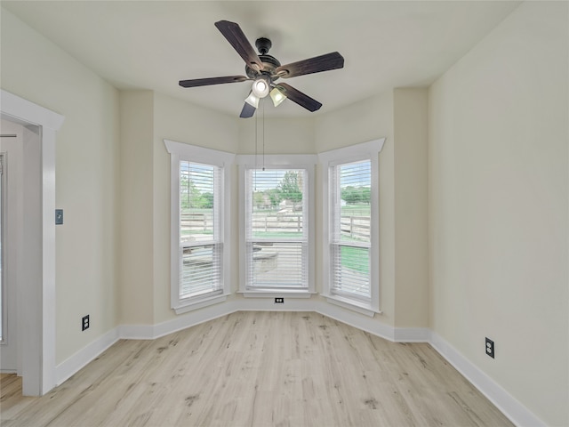 spare room with light wood-type flooring and ceiling fan