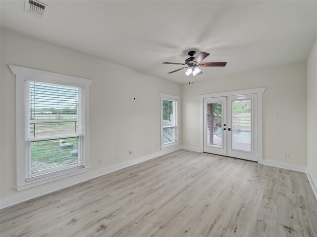 empty room featuring ceiling fan, light hardwood / wood-style flooring, and french doors